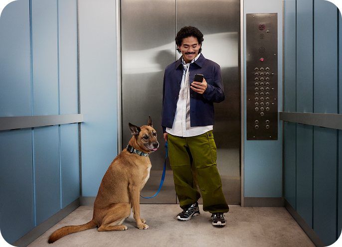 image of man with dog in front of an elevator