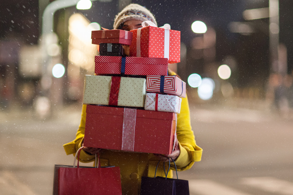 woman carrying stack of gifts