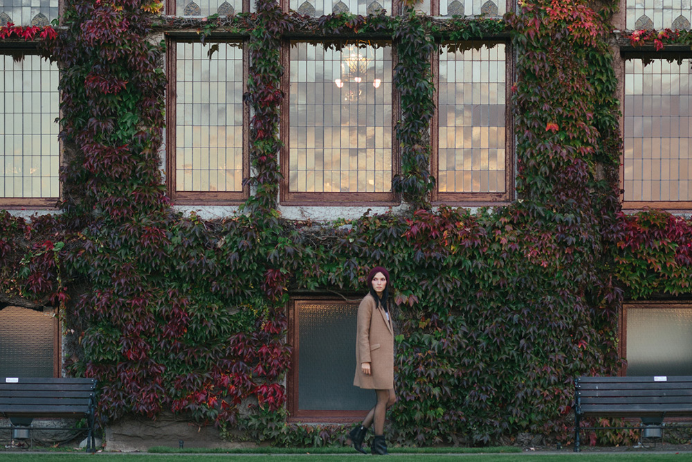 woman walking by ivy building