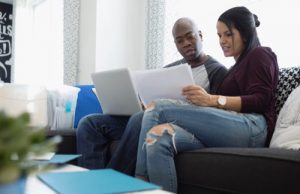 Couple with laptop budgeting in living room