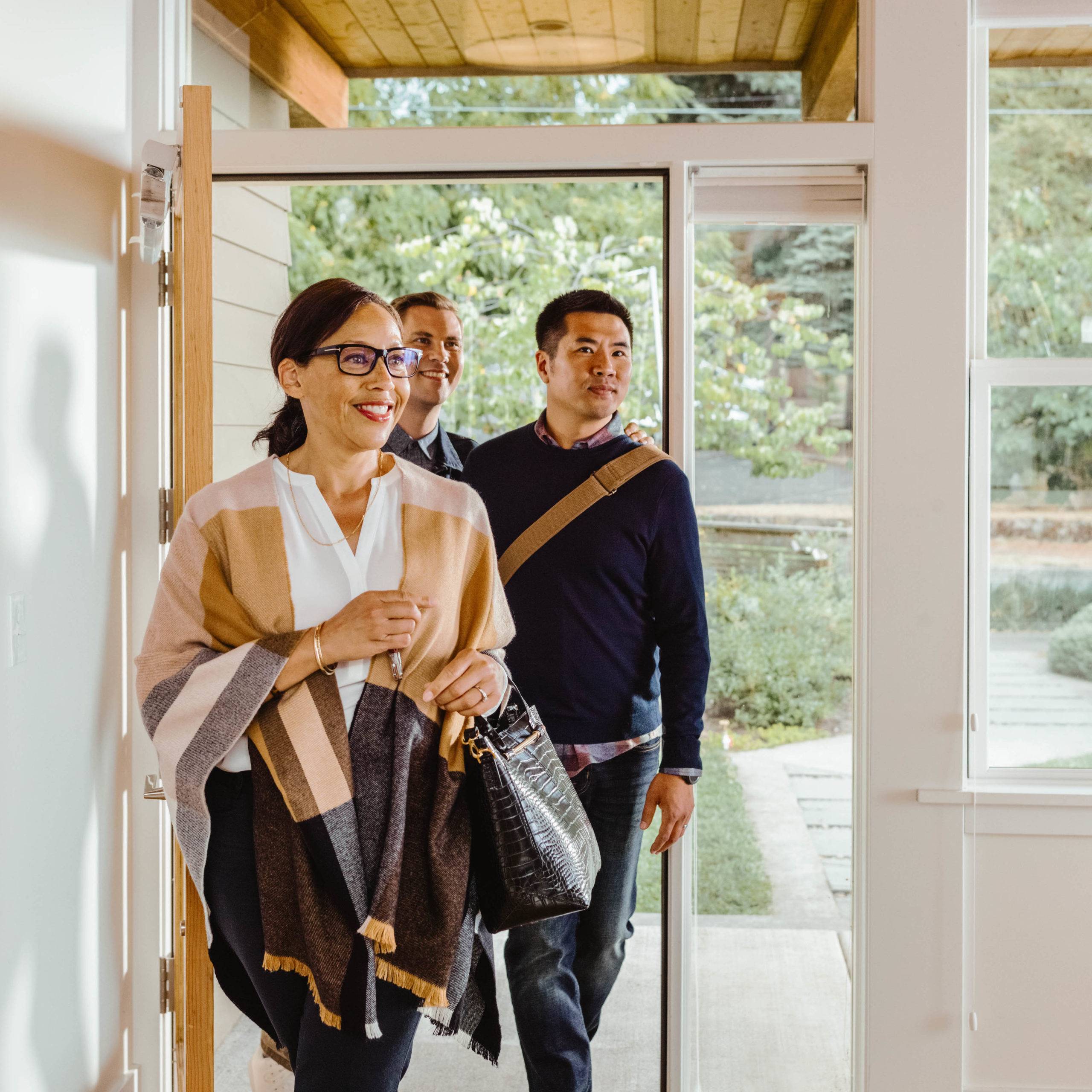 Real estate agent enters home with two clients