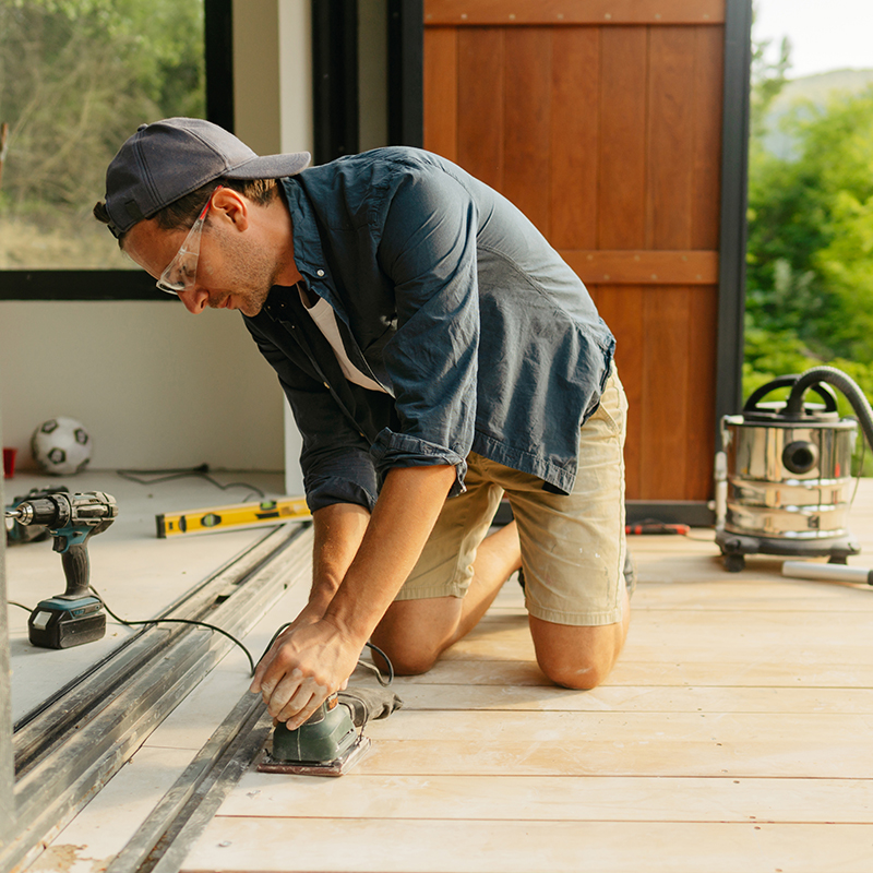 person sanding a deck