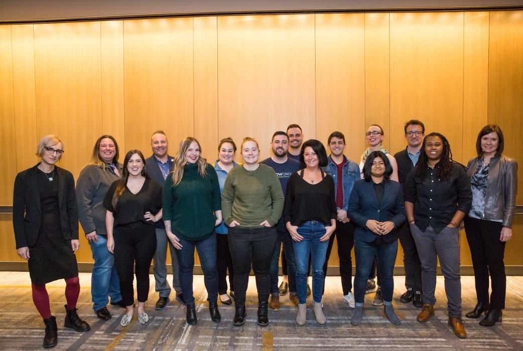 A dozen people pose for a group photo. They are leaders in the Zillow Pride affinity network.