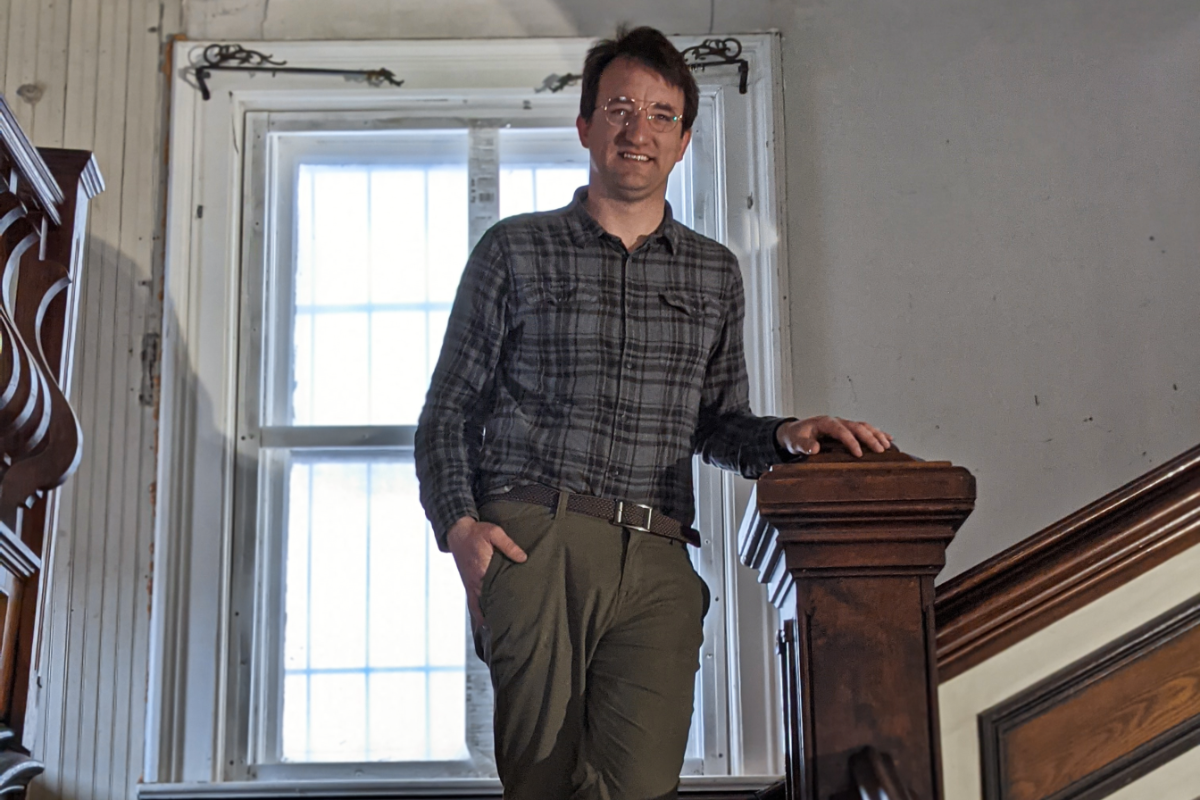 Man standing on stair landing in old building