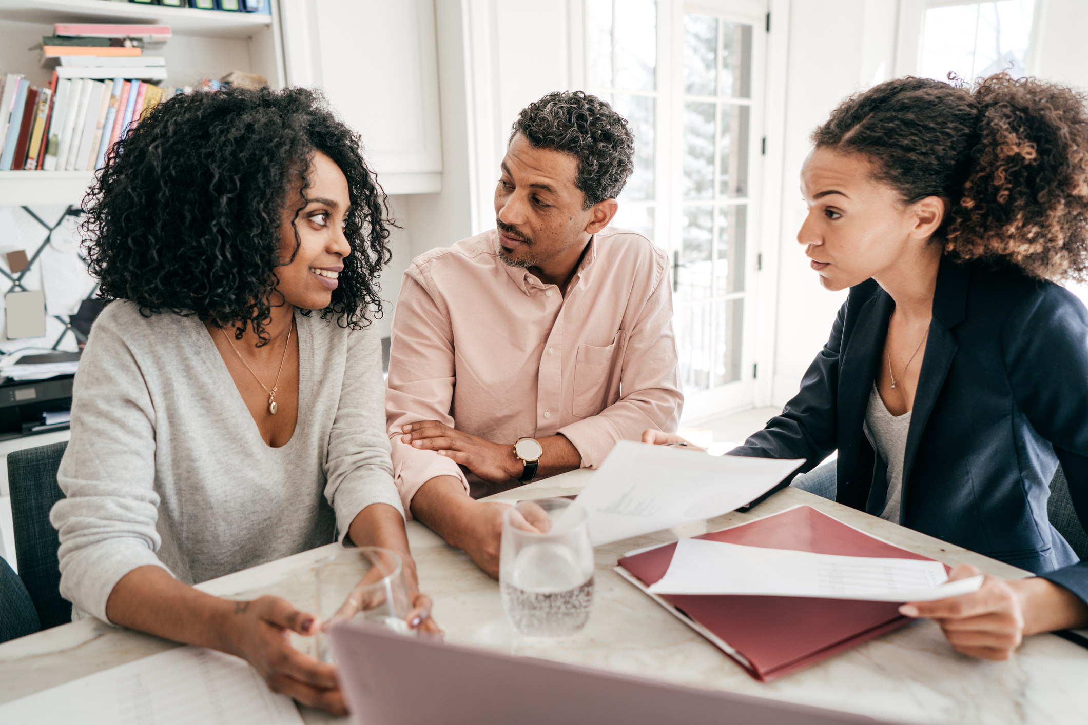 man and woman sitting at table talking to real estate agent