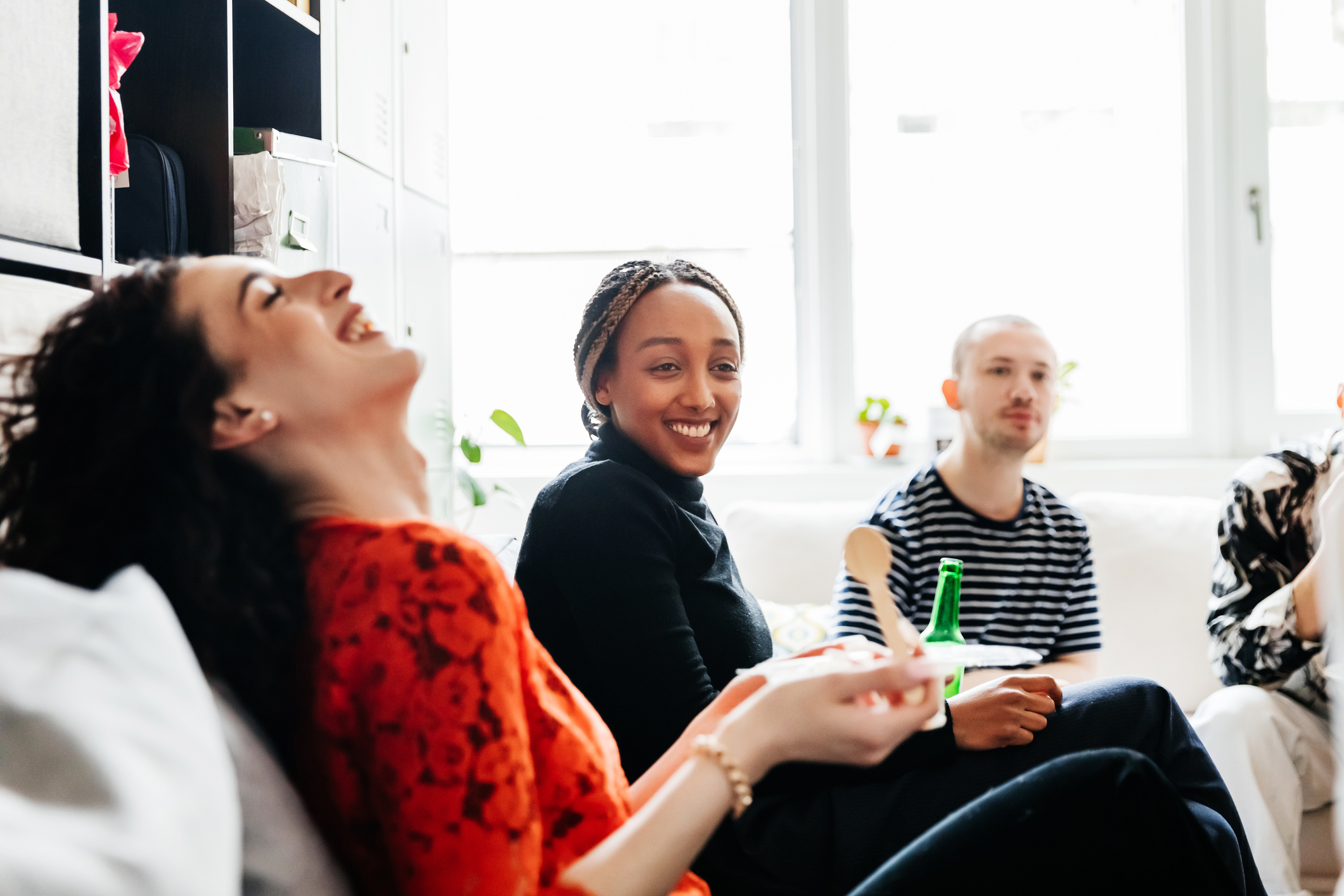 three people in living room laughing