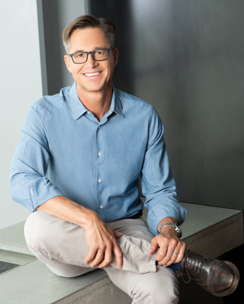 Zillow CEO Rich Barton wearing navy blue sportcoat, his arms crossed over his waist