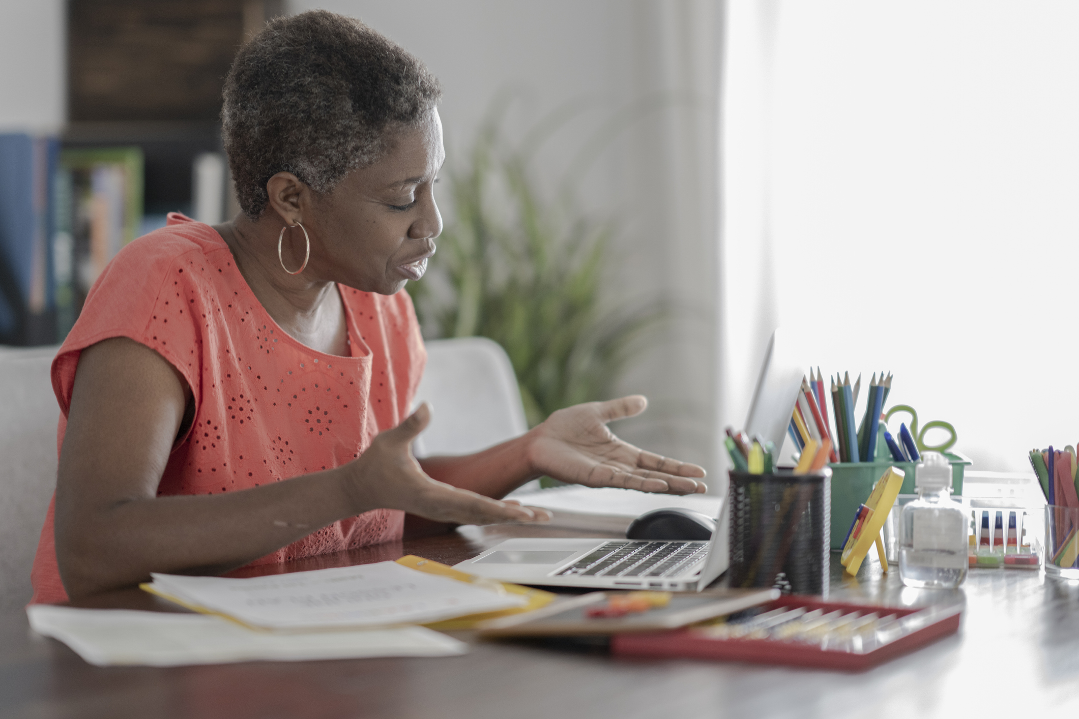 Black woman at desk looking into computer screen