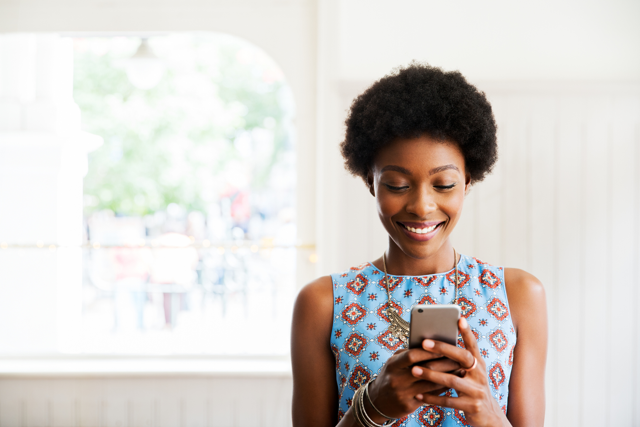 woman smiling looking at floor plan on her smart phone