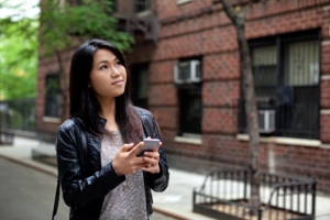 young woman on nyc street wondering what do I need to rent an apartment in nyc
