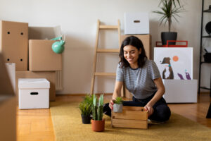 Woman sits on floor of new apartment after move-in renters insurance in NYC