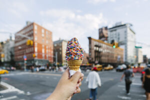 Hand holding ice cream cone on NYC street ice cream in NYC