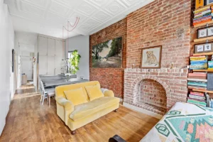 living room and kitchen with exposed brick in renovated Chelsea 1-bedroom