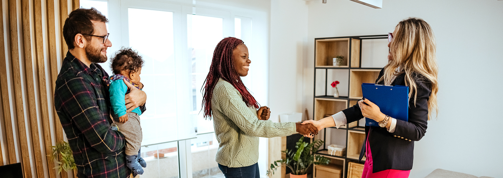 agent shaking hands with woman while man holds baby - sell your home fast in NYC