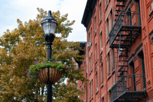 Hanging flowerpot on street lamp in front of brick rowhouses in Hoboken - best places to live in New Jersey