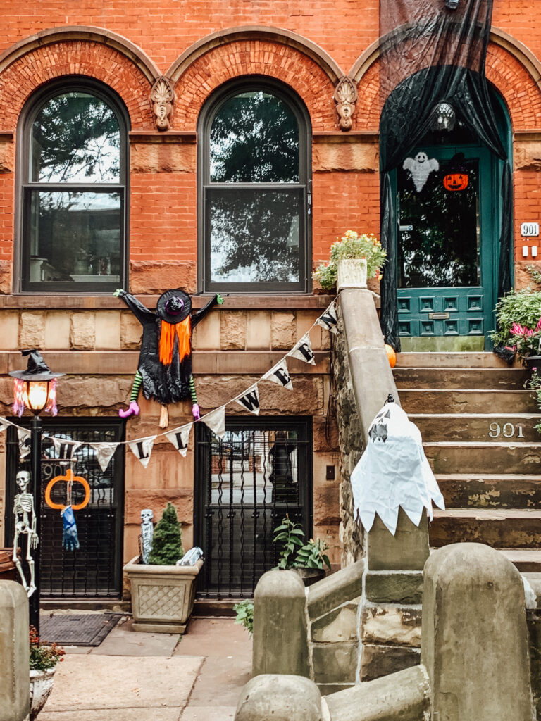 Halloween decorations in front of brick NYC townhouse.