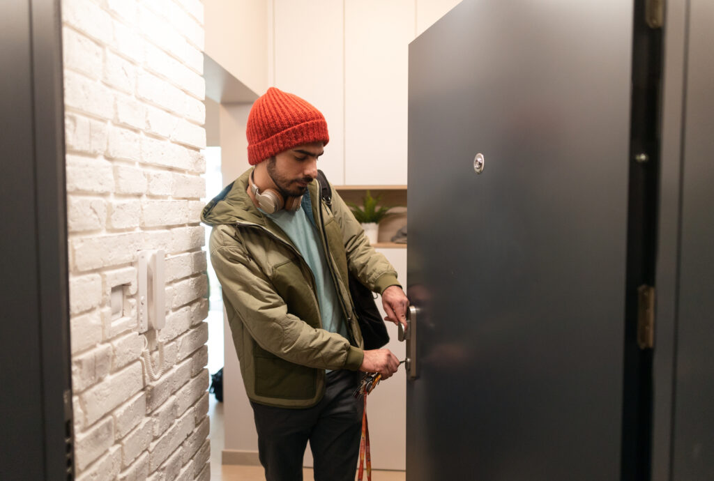 young man locking door on way out - prepare nyc apartment before traveling