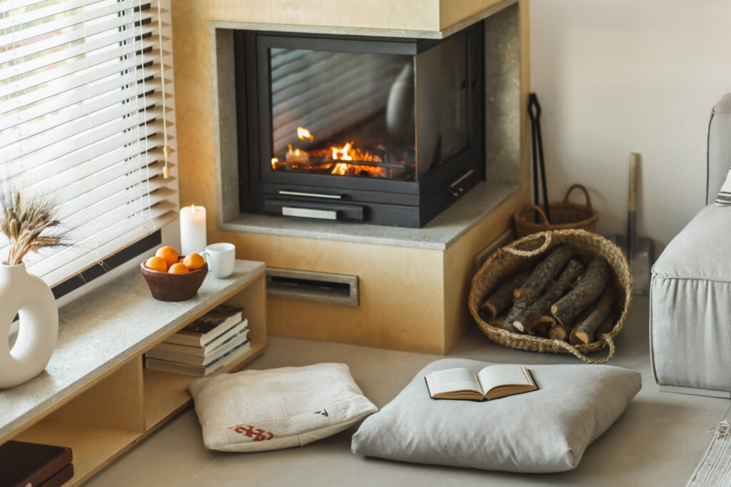 candle, mug, and bowl of oranges decorate living room in front of fireplace - decorate your nyc apartment for holidays