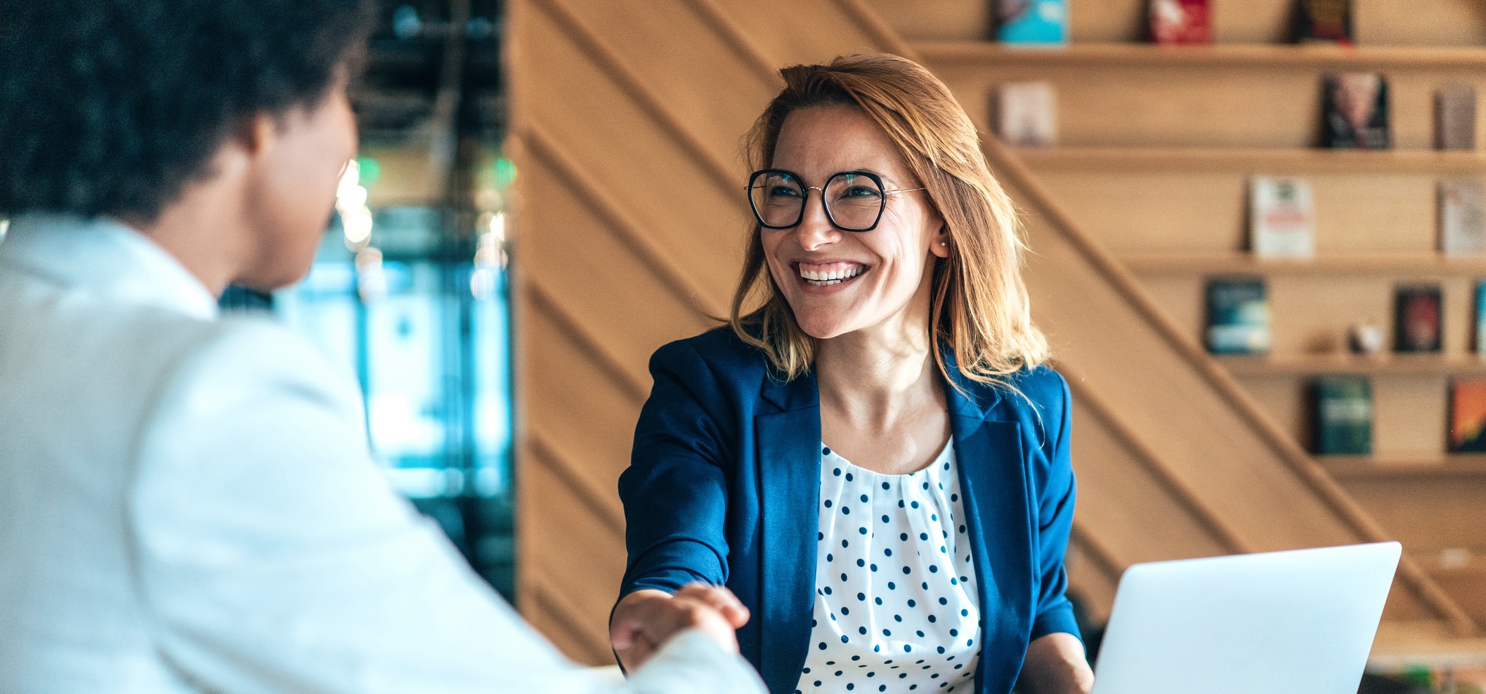 hero image - shaking hands with smiling agent on laptop - how to choose a listing agent