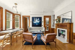 Living room with lots of wood and decorative fireplace in Fort Greene home