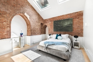 bedroom with brick archway and skylight in Fort Greene