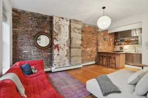 living room and kitchen with exposed brick in East Village 1-bedroom