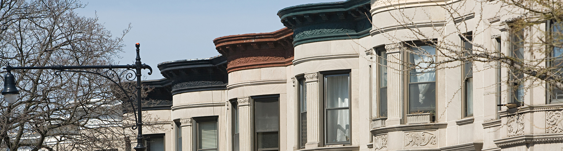 rent burdened - row of apartment buildings in nyc with different colored roofs