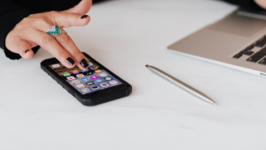 Woman using phone and laptop