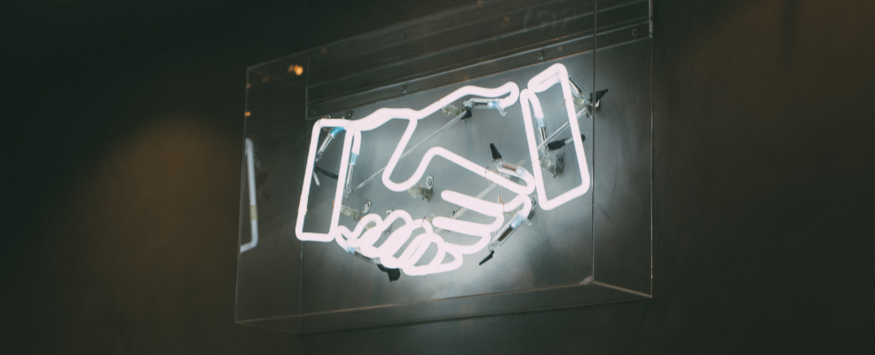 Neon sign of shaking hands