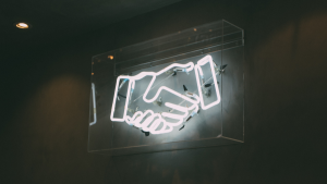 Neon sign of two hands shaking