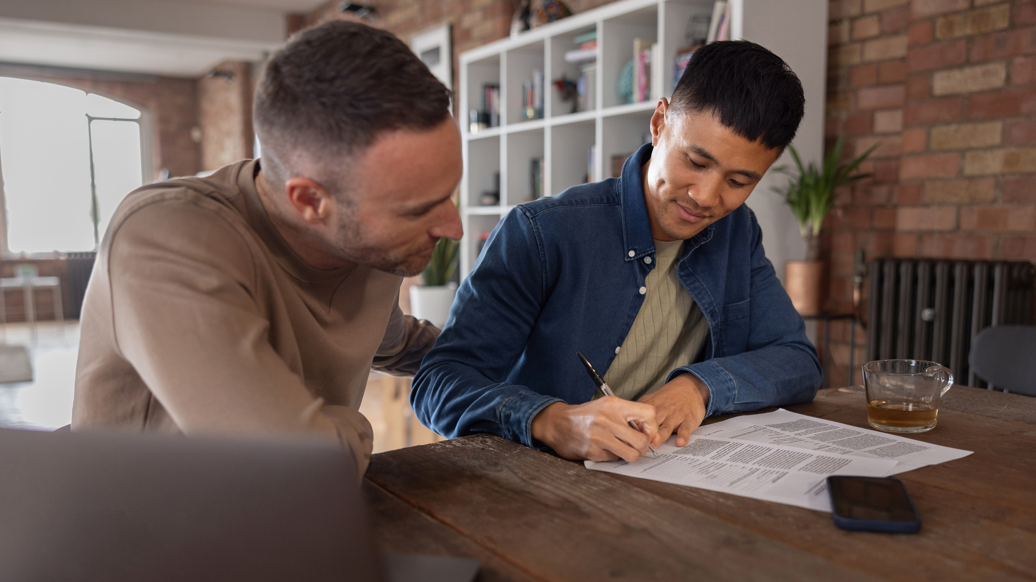 A young man signing a mortgage note.