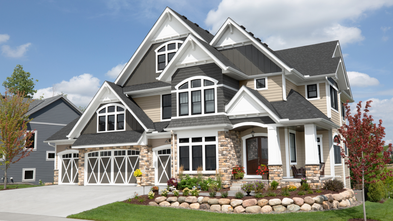 gray, white, and tan single family home exterior with manicured lawn.