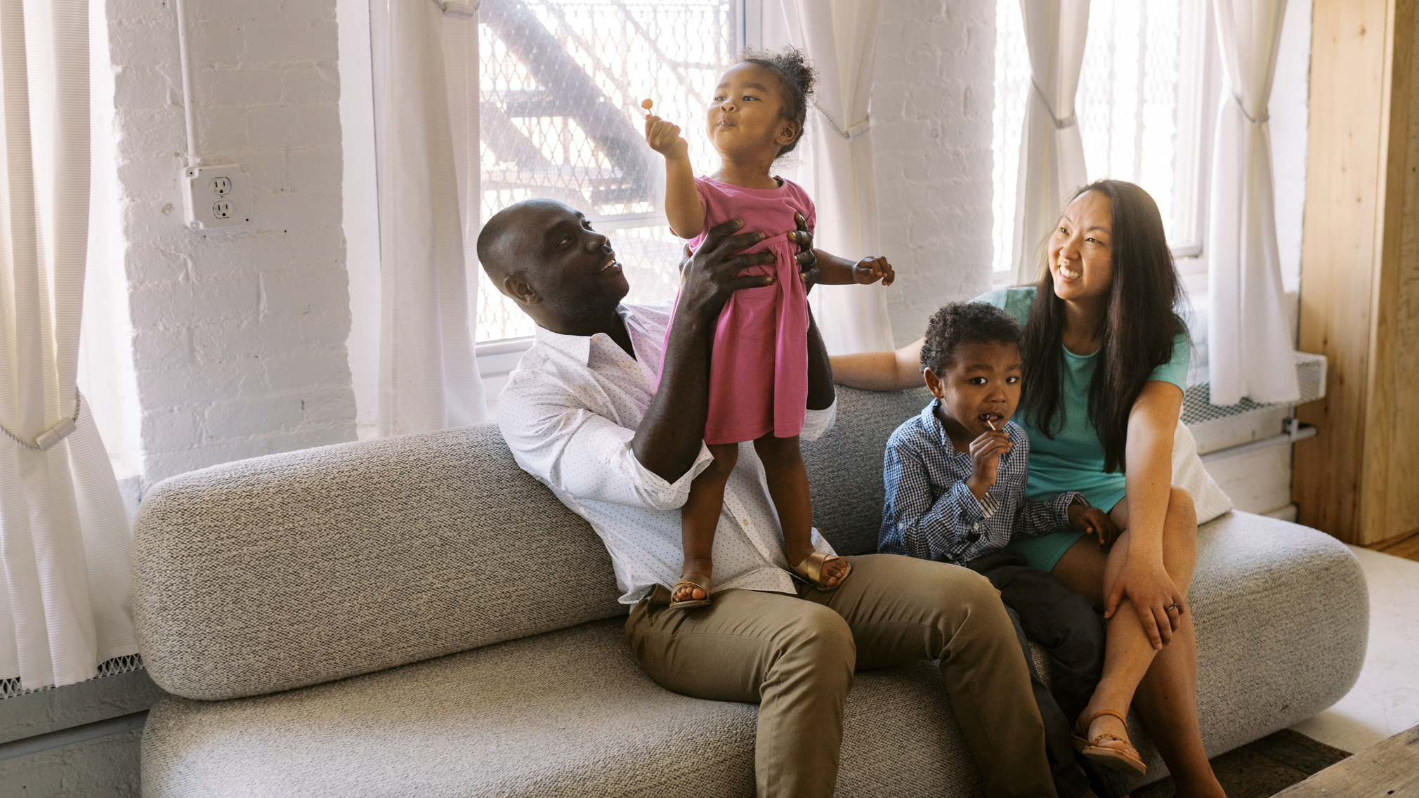 Happy family sitting together on a gray couch in the living room