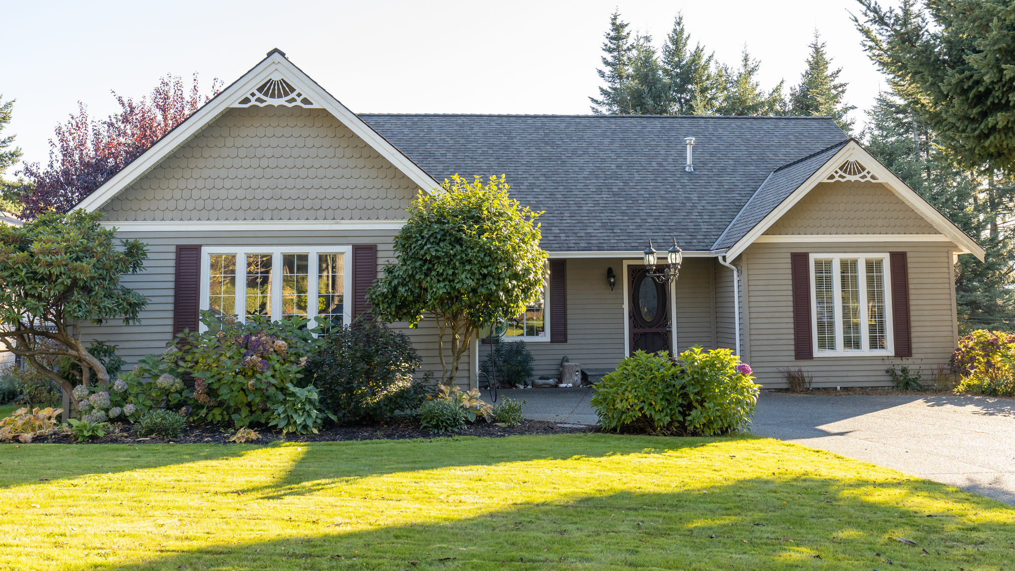 Exterior of brown and white painted single family home with a great lawn