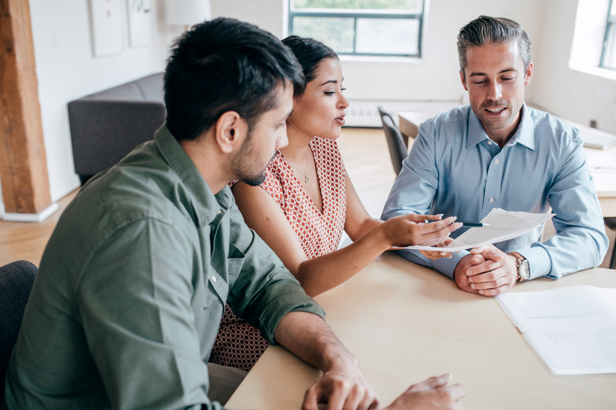 A couple discussing UFMIP on a FHA loan with their mortgage lender.