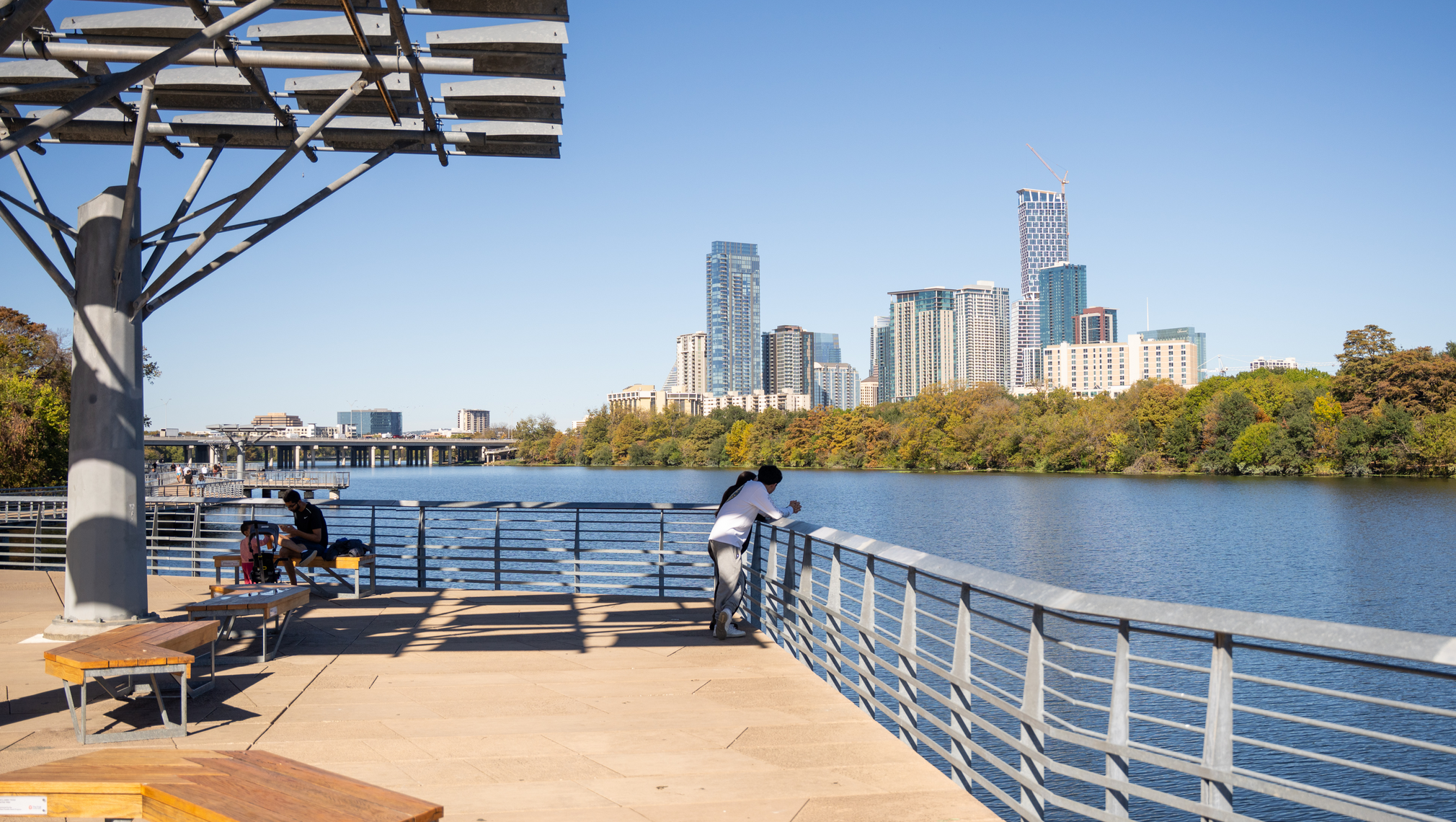 An overlook above a waterway in Austin, with downtown highrises in the distance.