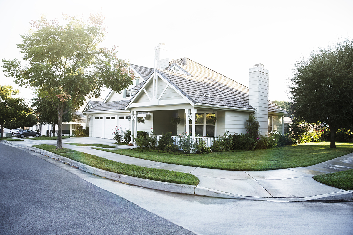 Suburban home on a corner with sidewalks on both sides.