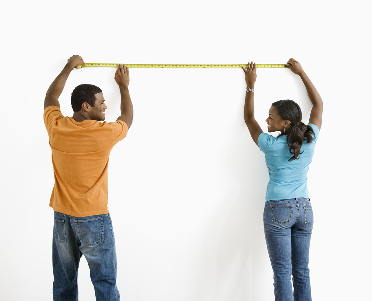 Man and woman measuring a house to compute square footage
