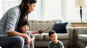 family with mother and two children sitting in living room