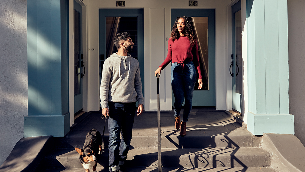Man and woman walking down steps with dog