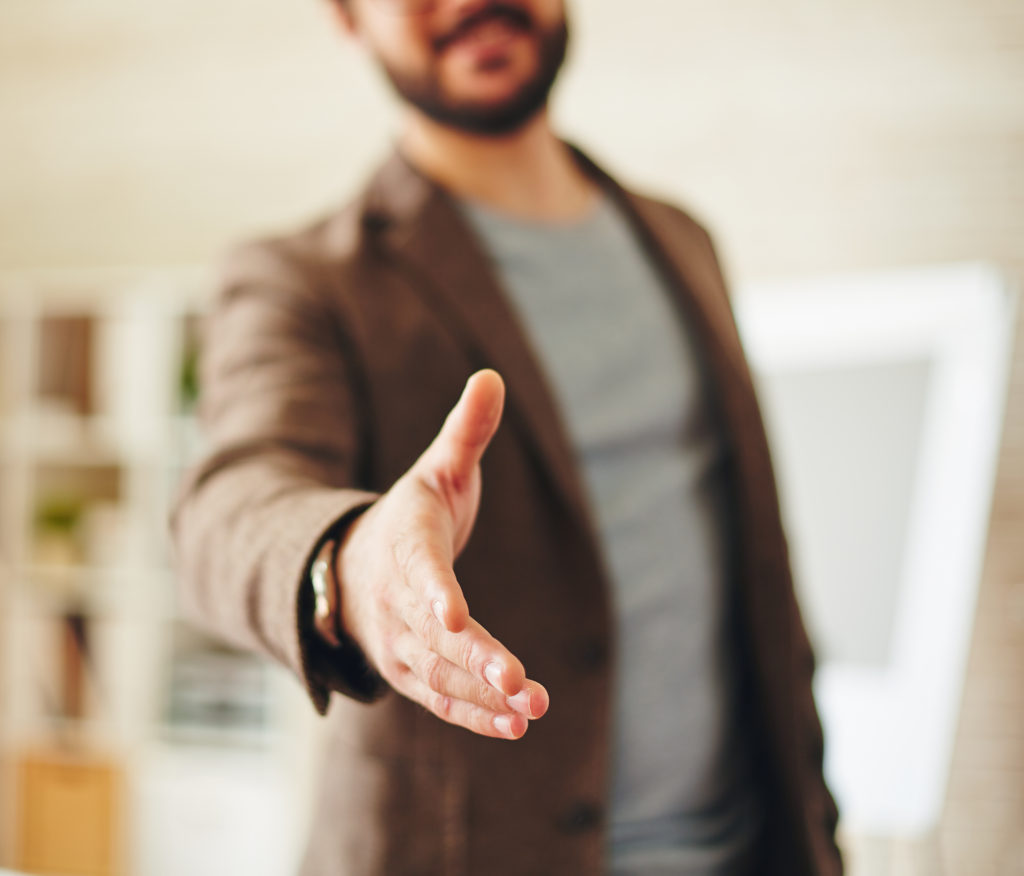 A property manager greeting a tenant at a rental property.