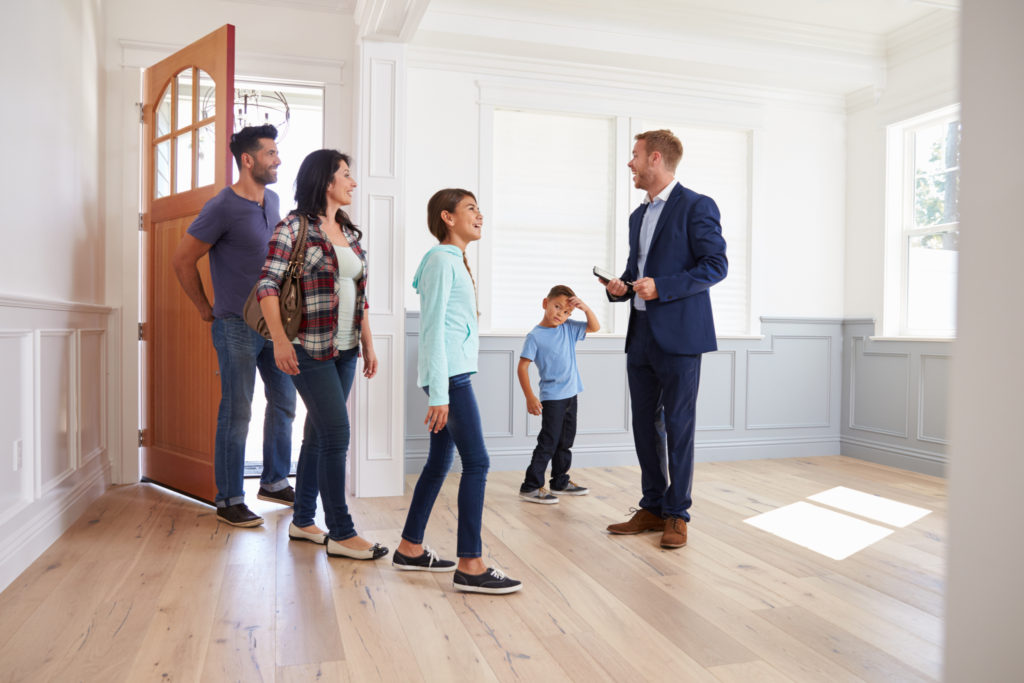 A landlord showing an apartment to renters at a rental open house.