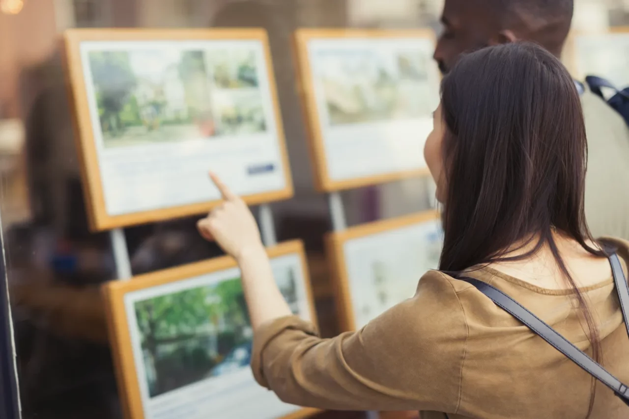 A couple of buyers looking at real estate flyers.
