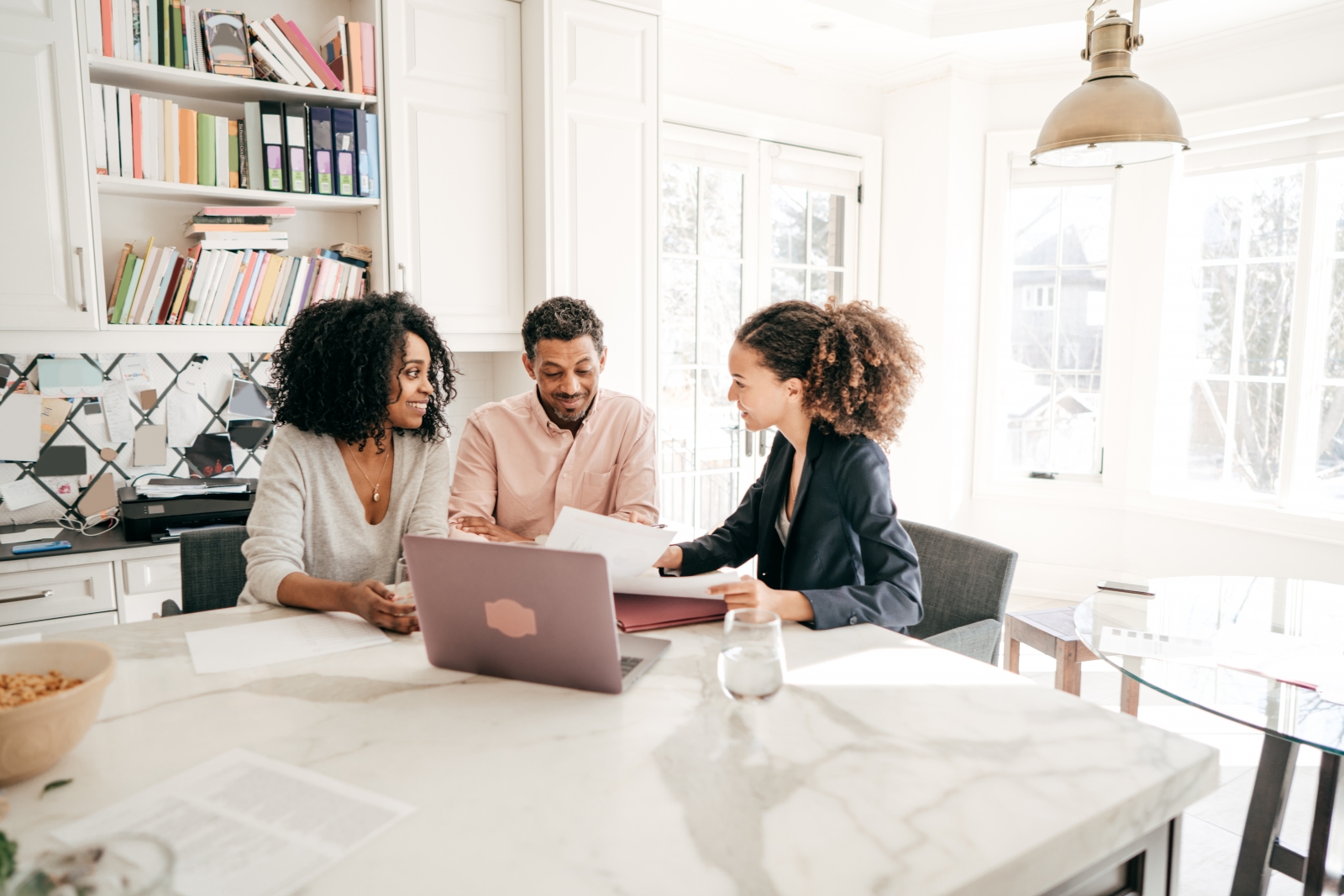 Home shoppers and agent gathered around a laptop