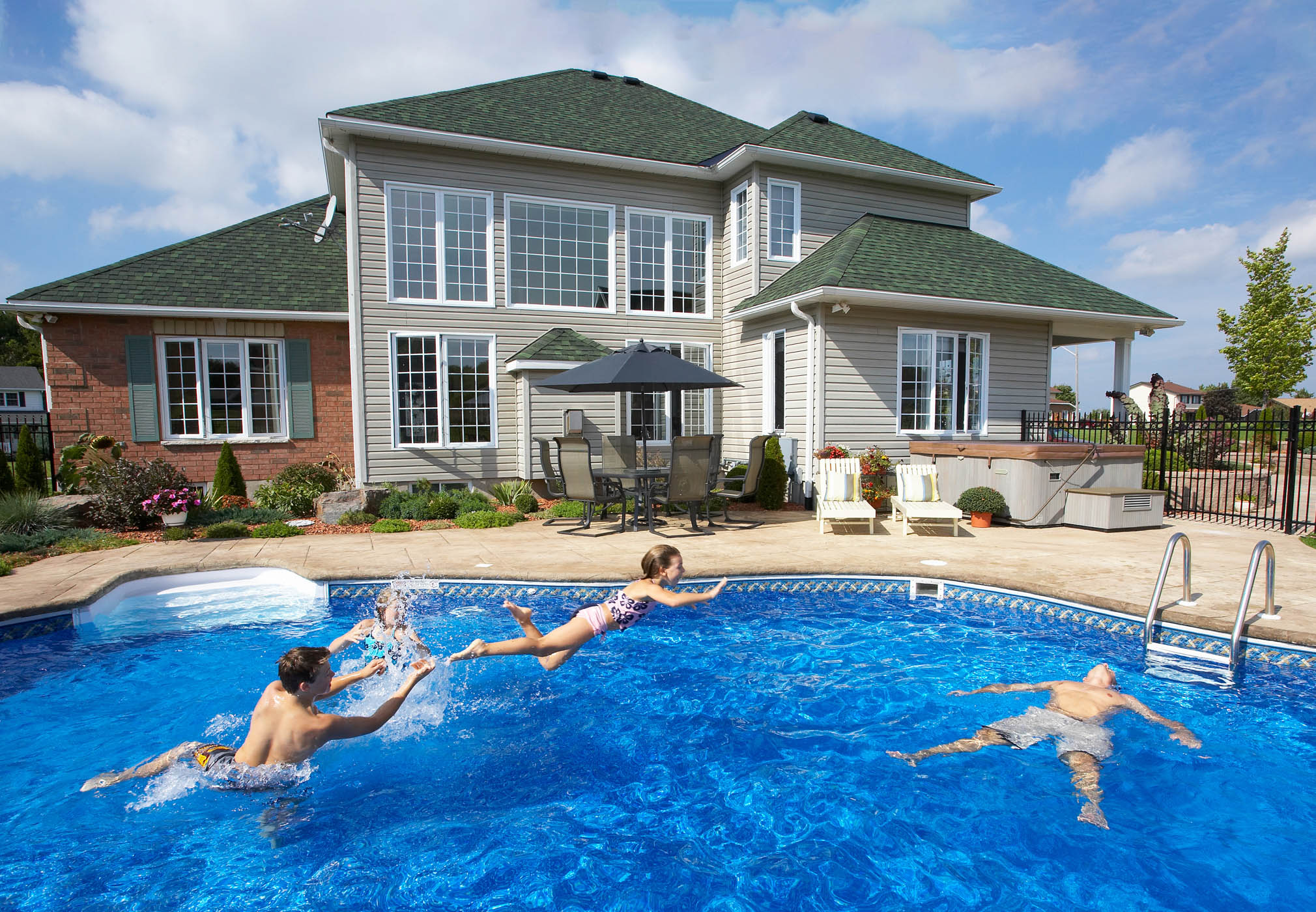 Family playing in backyard pool