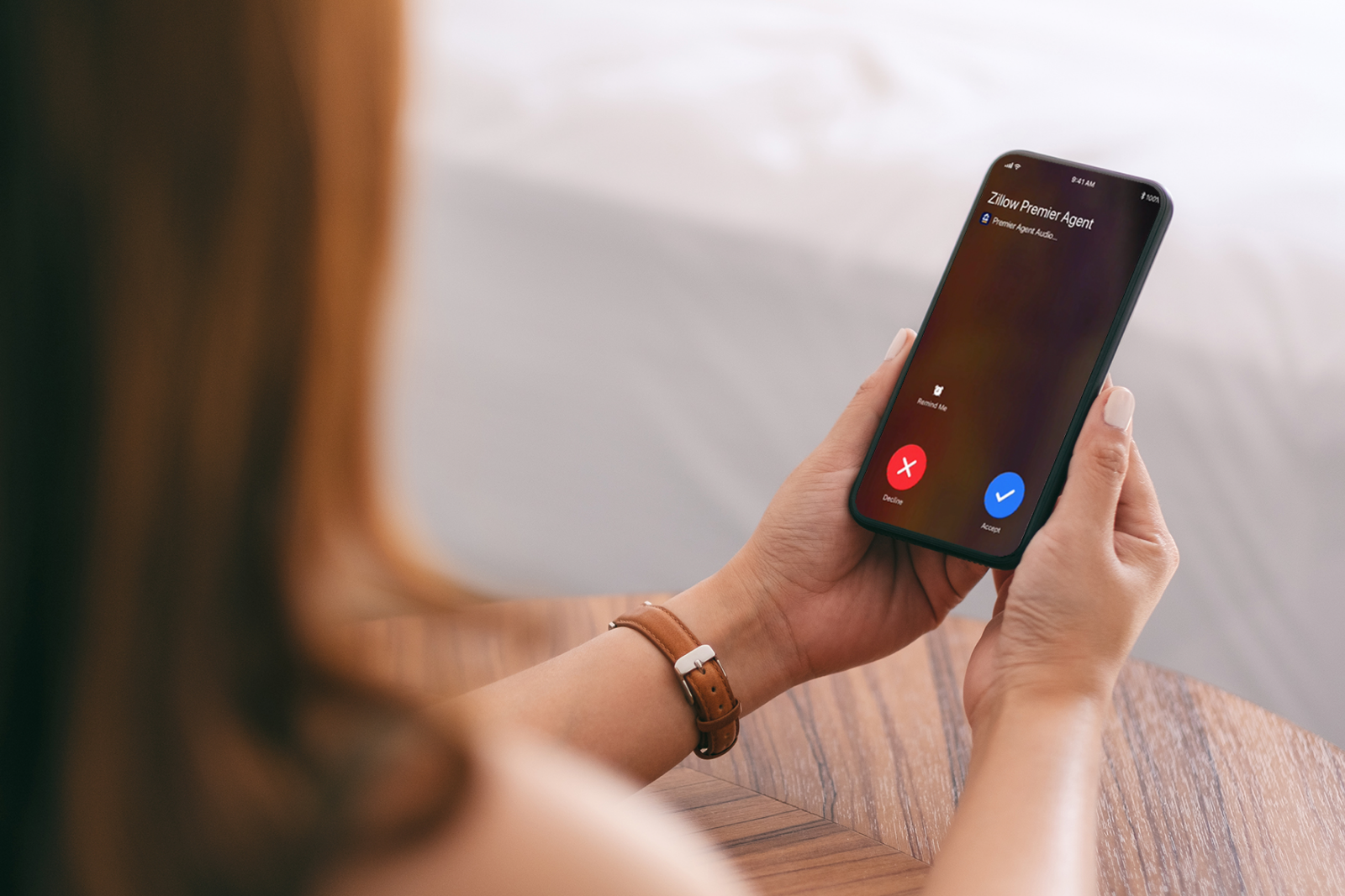 over-the-shoulder photo of a female agent receiving a connection call on her cellphone from Zillow Premier Agent