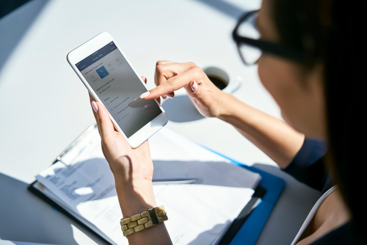 Woman looks at Zillow Premier Agent app on her phone