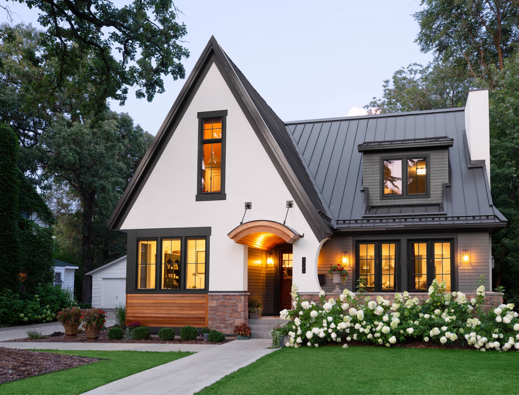 A house with a lawn and all windows illuminated.