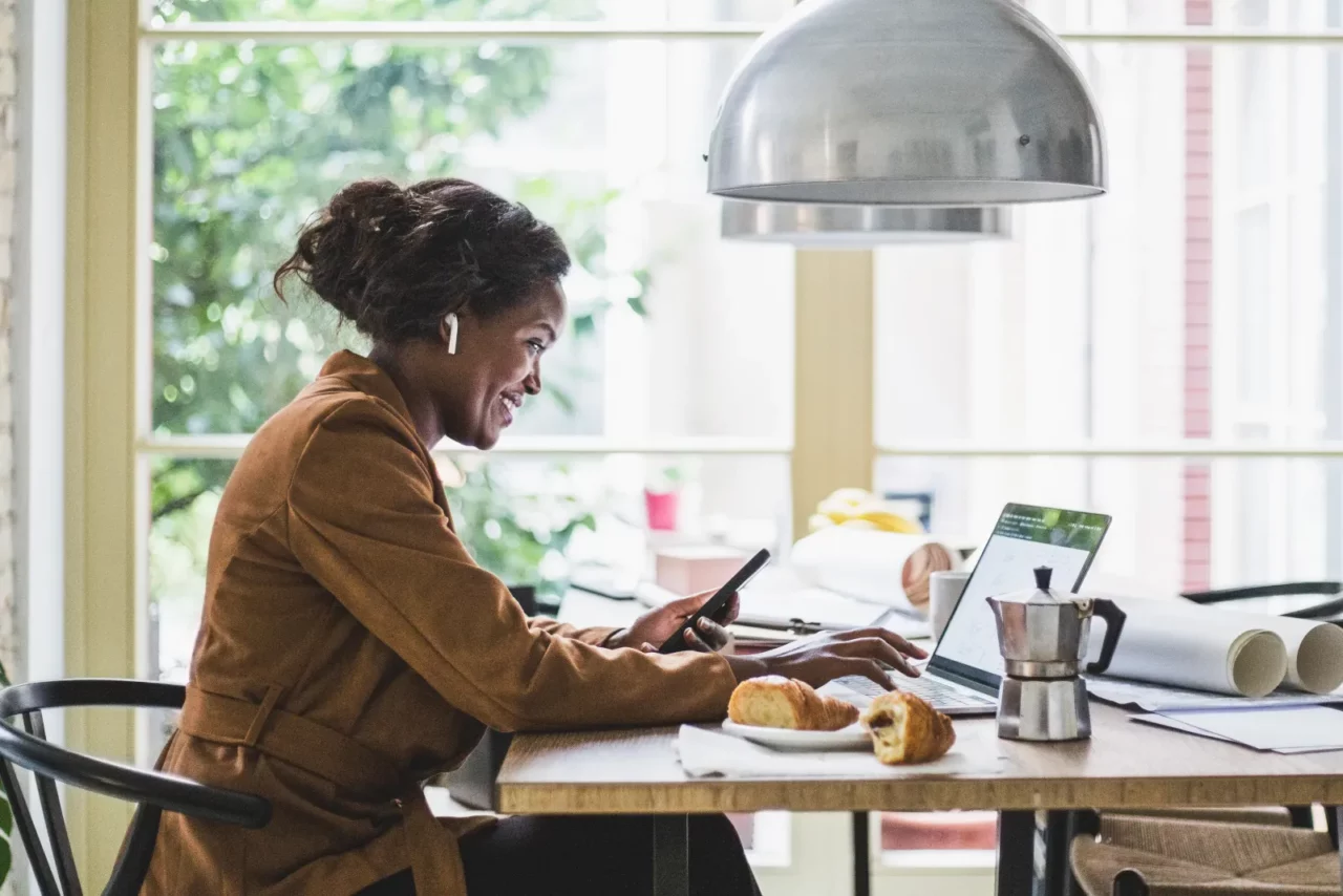 woman on the phone looking at her laptop