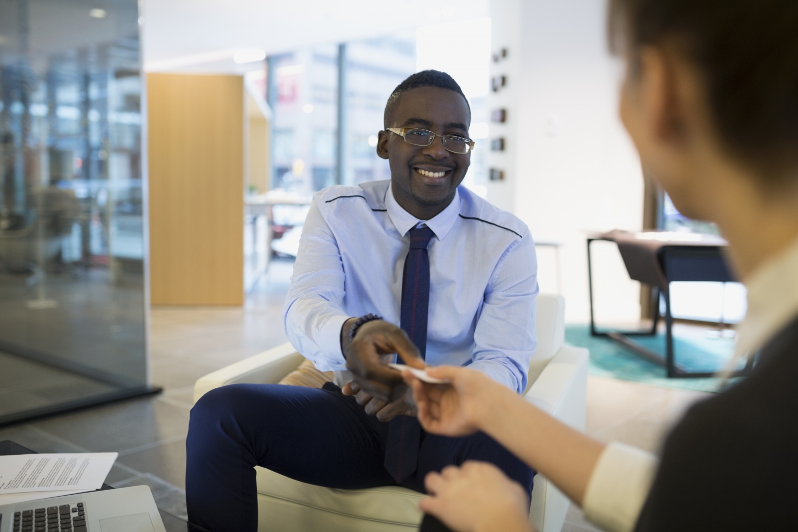 A real estate agent handing their business card to a client.